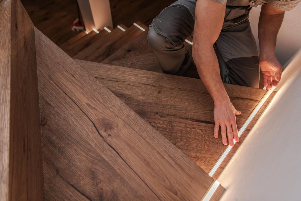 worker-installs-light-strips-wooden-staircase-steps_1426-26795 pose de parquet sur mesure